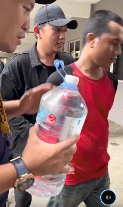 这批男子将罗兴亚男的双手押在身后,恫言要把对方带到警局,而罗兴亚男子全程面无表情,也没有反抗。(视频截图)