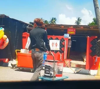 一名男子使用手推车,将两个装有自来水的饮料桶从厕所外运走。(视频截图/Threads@zaidonmuhammadamri)