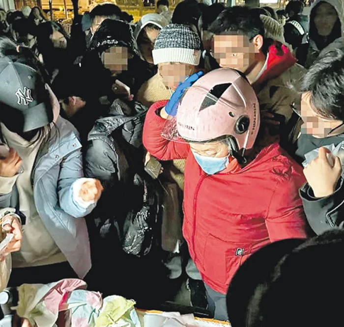 中国北京知名摊贩“鹅腿阿姨”陈秀凤（红衣者），近日陷入诚信争议，被网民指责虚假宣传。（互联网照片）