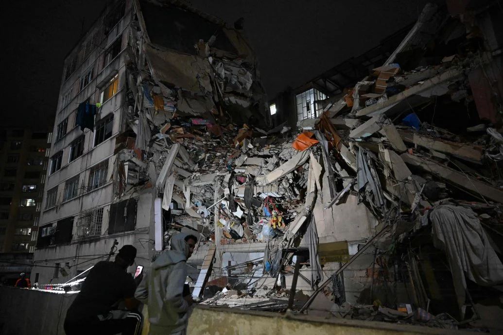 加拉加斯阿尔塔米拉一栋建筑大楼倒塌，志工爬上瓦砾堆上方搜寻生还者。（法新社照片）