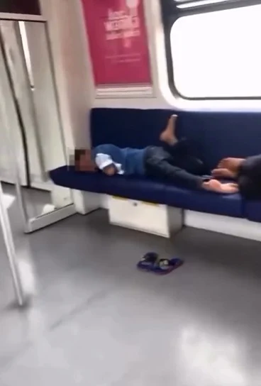 把车厢座位当睡床，这行为让网民无法接受，纷纷进行谴责。（视频截图）