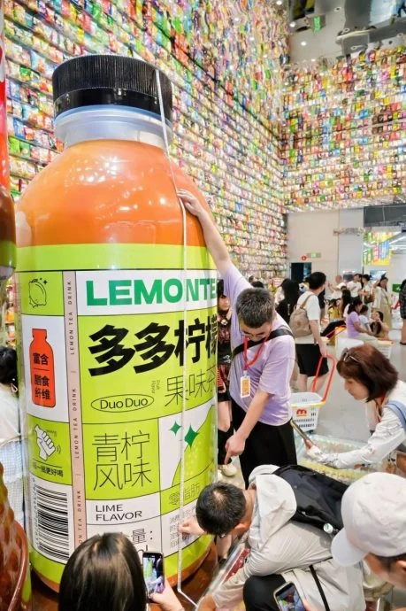 游客测量零食王国巨型零食模型。（《潇湘晨报》照片）
