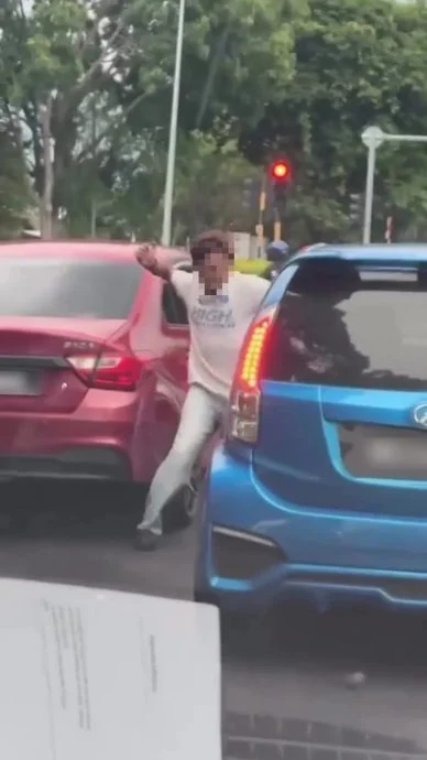 巫裔男子怒气地从Saga走下车，然后大力敲打蓝色Myvi的车窗。（视频截图）