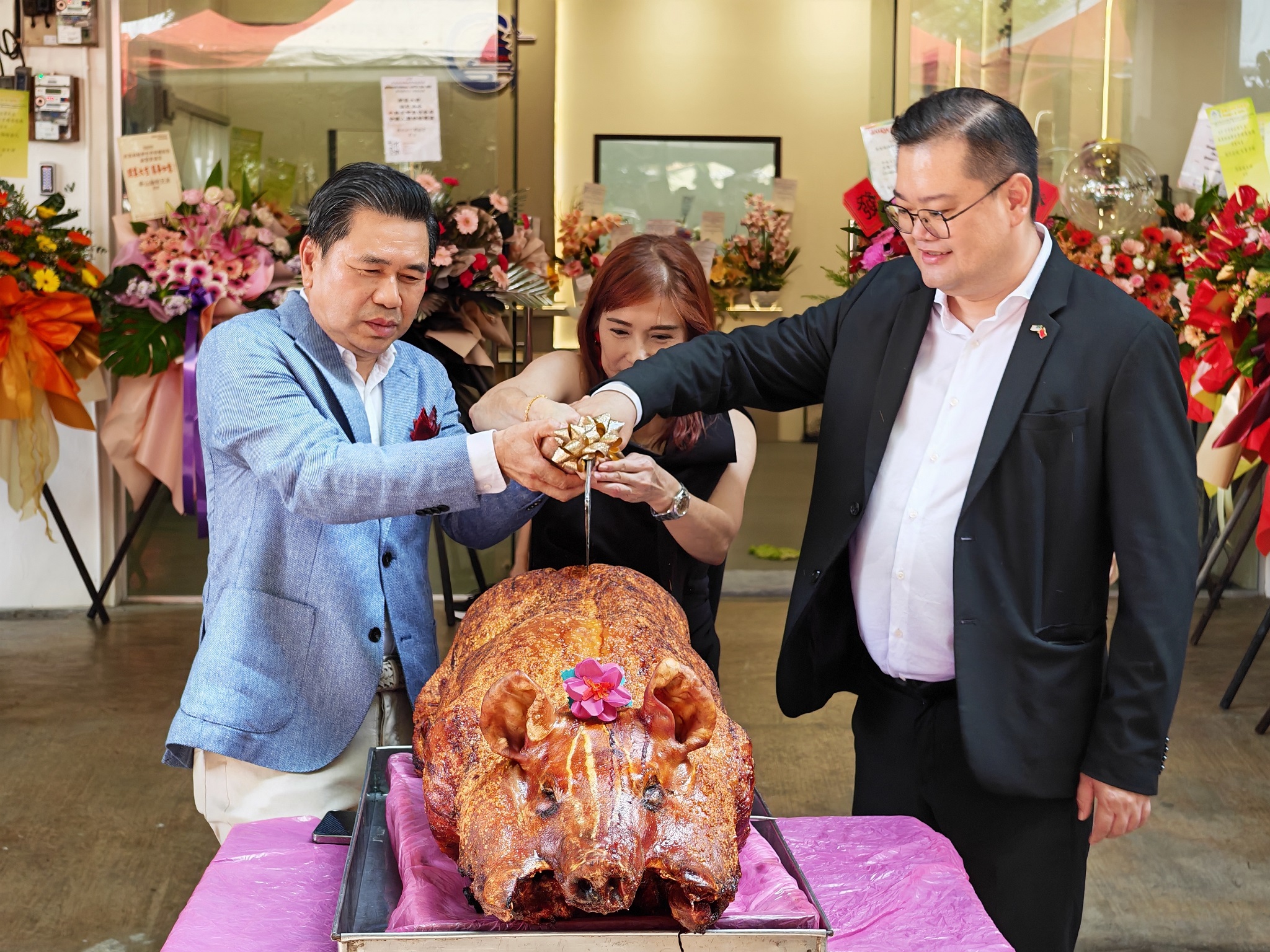 黄汉荣(左)、王翎凤及谢政毅切烧猪。