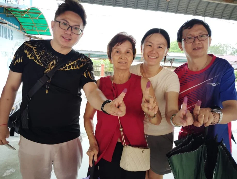 刘玉芳（左二）与孩子们完成投票后，开心地展示染墨手指。左一蔡家祥，右起蔡家幸及蔡凤茹。