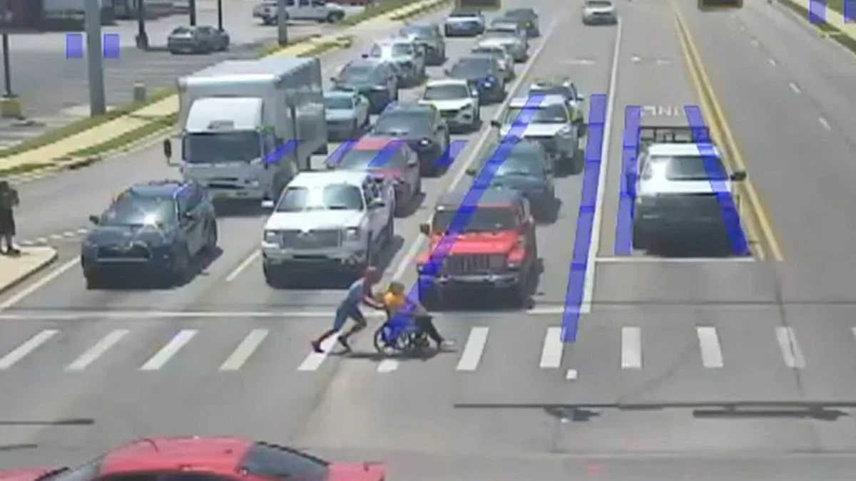 身穿“蜘蛛侠”服装的男子迅速下车,将轮椅男迅速推到安全地带。(视频截图)