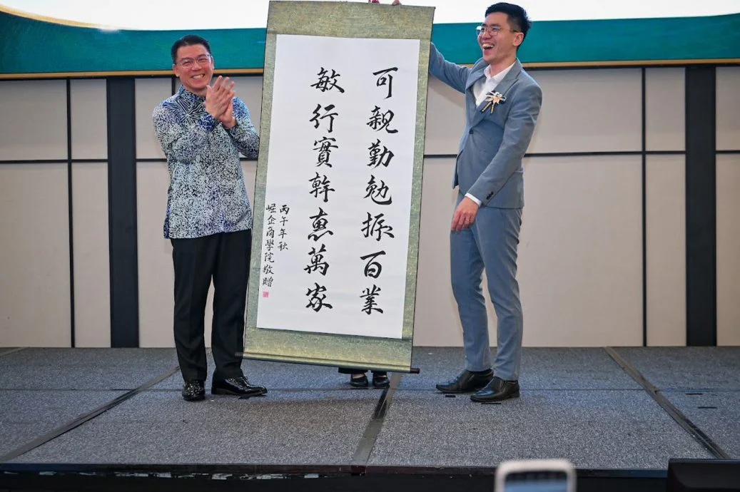 陈泳任(右)赠送以部长名字书写的墨宝纪念品予倪可敏。(房地部提供)
